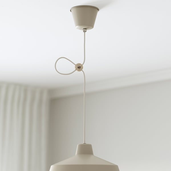 En beige pendel hænger fra et loft med en justerbar ledning, der giver rettet lys.
