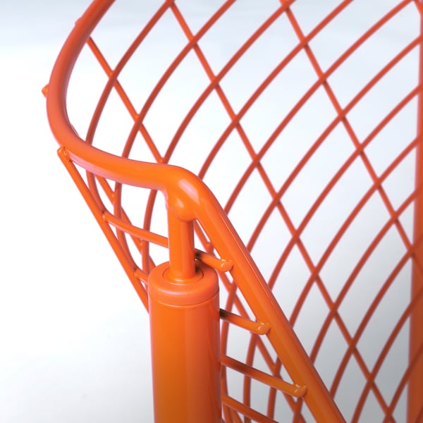 Lys orange metalstol med indviklet gitterryg, robuste cylindriske ben og slankt designfokus