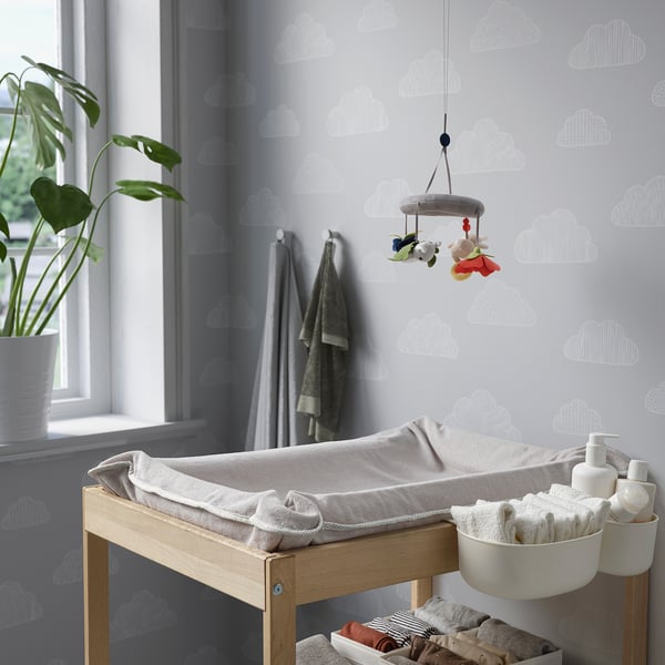 Børnehave med sky tapet, puslebord, mobil, plante, håndklæder.