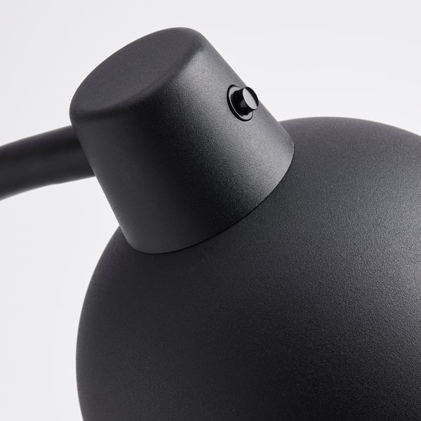 Nærbillede af moderne sort lampe. Tekstureret, robust design. Fleksible led til justeringer. Solid metalkonstruktion.