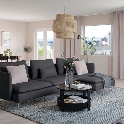 Moderne stue med sort SÖDERHAMN sektionssofa, gråt tæppe og stort vindue. Sofaens størrelse fremhæves af det rummelige værelse.