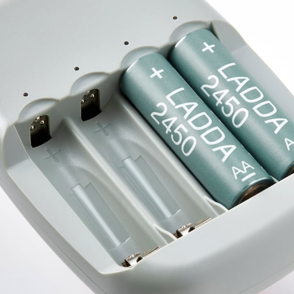 To grønne ladda 2450 batterier sikkert placeret i en hvid STENKOL batterioplader, klar til opladning.