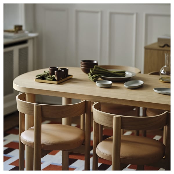 Moderne spisebord med egetræsfiner og træstole med minimalistisk design.