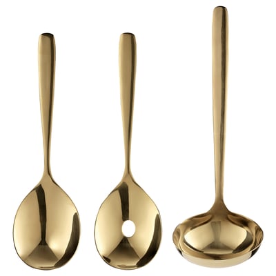 Tre messingfarvede TILLAGD-redskaber: en ske, en øse og en serveringsske, hver lavet af rustfrit stål med et slankt og elegant design.