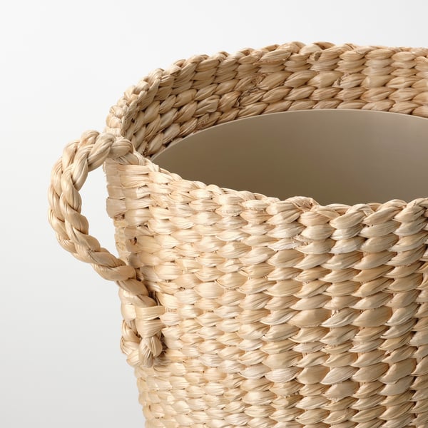 Håndvævet kurv i naturfiber med robuste håndtag, der viser indviklede teksturer og håndværk.