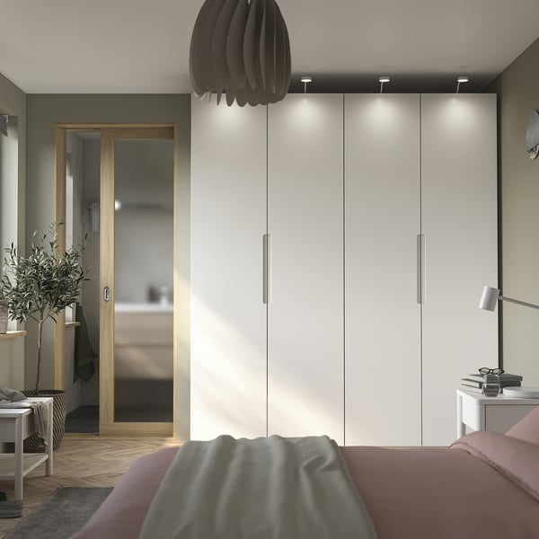 Moderne soveværelse med råhvid TONSTAD dør, garderobe og seng med lyserødt sengetøj.