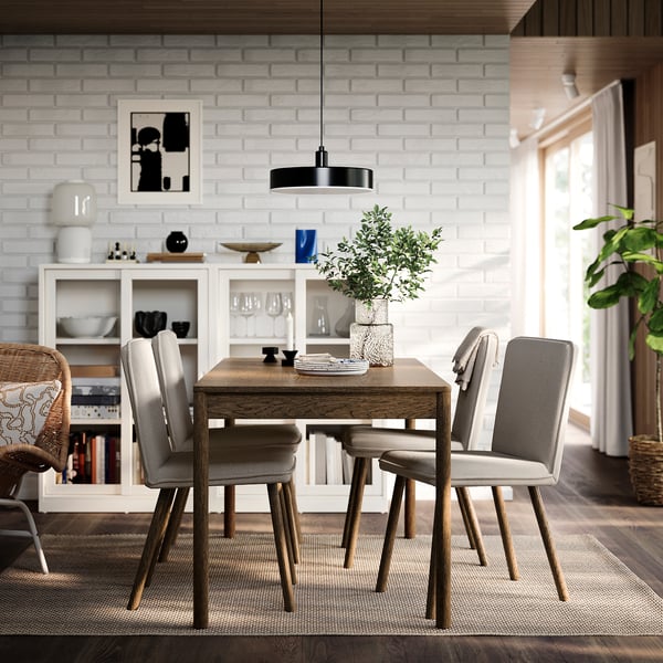Moderne spisestue med TONSTAD stole omkring mørkt træbord, hvid murstensvæg og stort vindue.