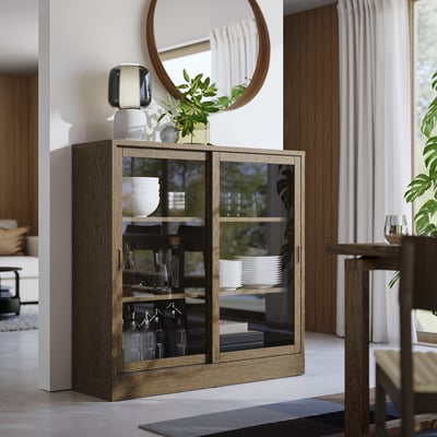 TONSTAD skab med glaslåger, egetræsfinish, rektangulær form, moderne design, mellemstørrelse, vist ved et spisebord.