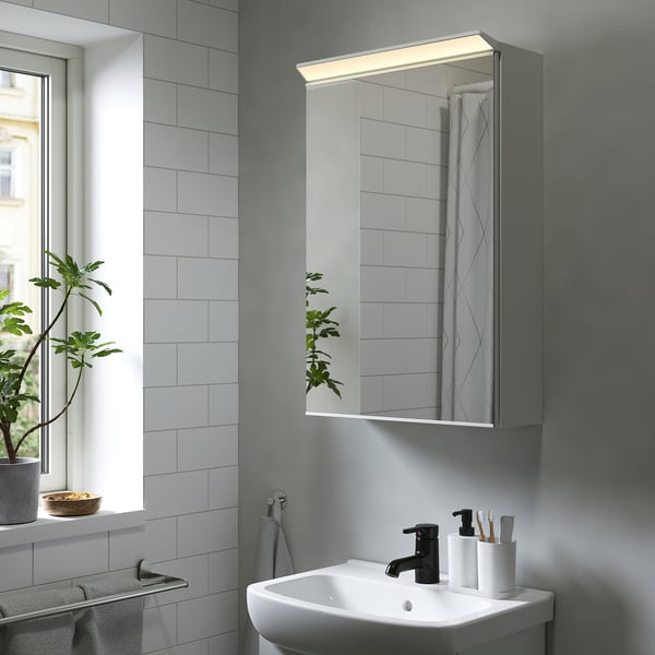 TREASJÖN spejlskab med led-belysning over vasken, grå abs og fiberplade, minimalistisk design.