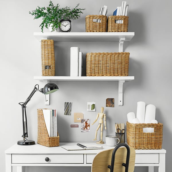 Arbejdsplads med TRUMMIS kurve, lampe, ur, planter, kunstartikler på hvidt skrivebord/stol.