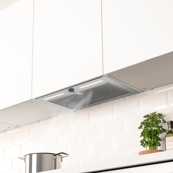 Emhætte i rustfrit stål med led-lys skjult i køkkenskabet, der giver et rent udseende og effektiv ventilation.