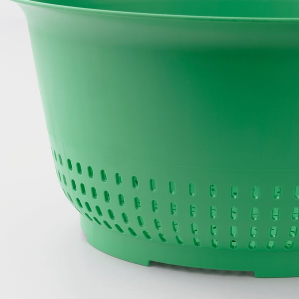 Grønt plastikdørslag nærbillede, der viser robust, perforeret design til dræning.