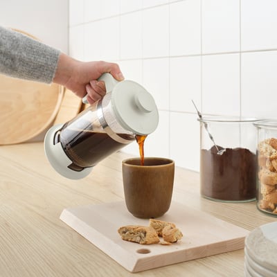 Hæld frisk kaffe fra UPPHETTA kaffe-/temaskine i et krus.