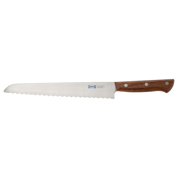 En savtakket brødkniv med et mørkt valnøddehåndtag, blad i rustfrit stål og tredobbelte nitter. Perfekt til at skære brød i skiver.