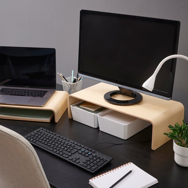 Træ skærmstativ med bærbar computer, tastaturopbevaring, på mørkt skrivebord. Inkluderer lampe, plante, trådløst tastatur og notesblok for effektiv arbejdsplads.