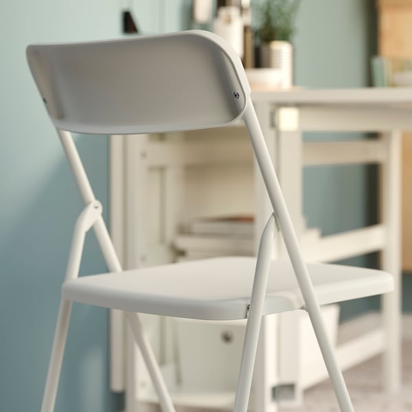 Moderne hvid sammenklappelig stol med slankt design, velegnet til små rum.