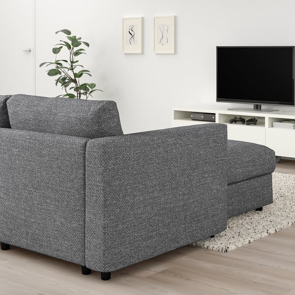 Moderne stue med VIMLE sektionssofa i gråt stof, plante, tv og kunst.