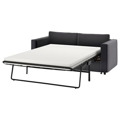 Moderne sort sovesofa med metalben.