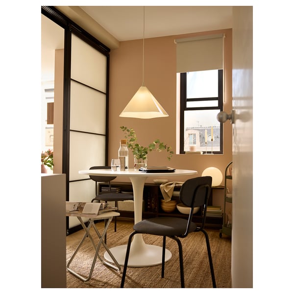 Moderne spiseplads med rundt bord, ZEBRASÄV lampe, vaser, glas, planter og lyst vindue.