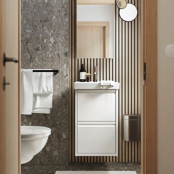 Modern bathroom with ÄNGSJÖN white vanity & grey marble wall.