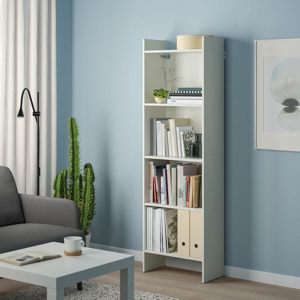 White BAGGEBO bookcase with blue accents, five shelves near grey couch.