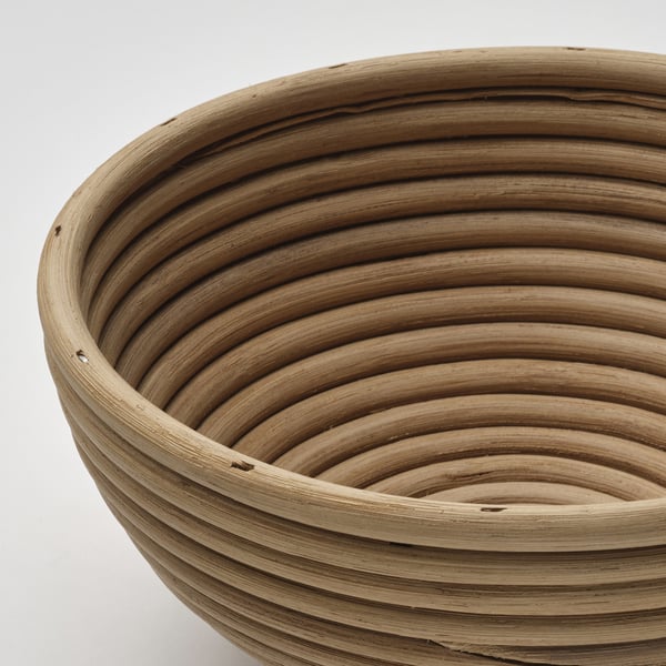 Close-up of a woven rattan proofing basket, showcasing intricate patterns and natural texture.