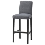 A grey BERGMUND bar stool with a cushioned seat and back, supported by a black metal frame.