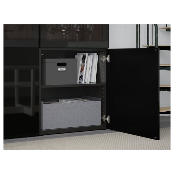Open black BESTÅ cabinet displaying storage boxes and magazines on shelves.