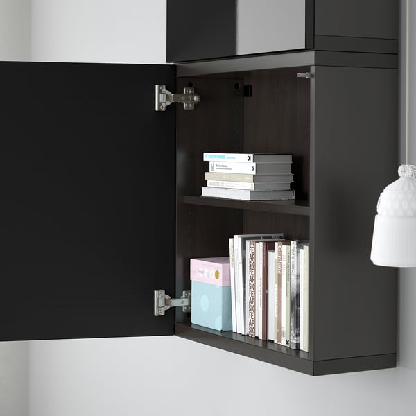 Black wall-hung shelf unit with multiple storage shelves, holding books and boxes, part of BESTÅ series.