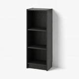 A black BILLY bookcase with three empty shelves, made of particle board, standing against a white wall.