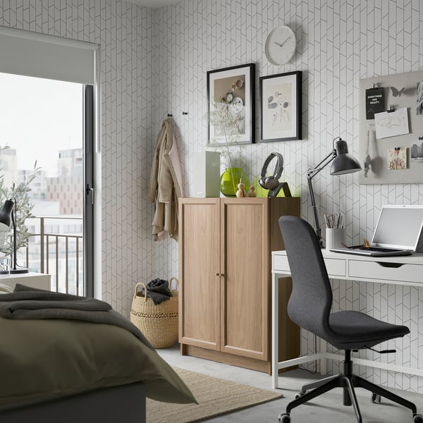Modern bedroom with BILLY bookcase, desk & office chair, green-pillowed bed.