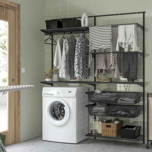 BOAXEL wall storage system: black metal, clothes, shelves, above white washing machine. Organised and modern laundry room.