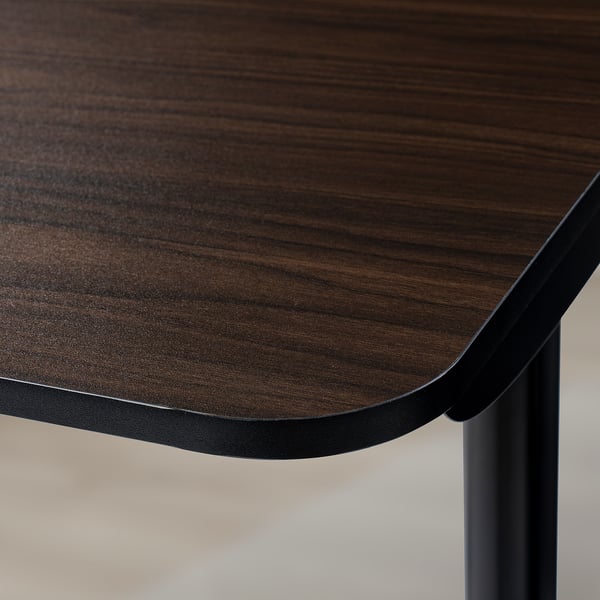Dark wooden table top with smooth, strong finish. Rounded edge detail, supported by sturdy metal legs beneath.