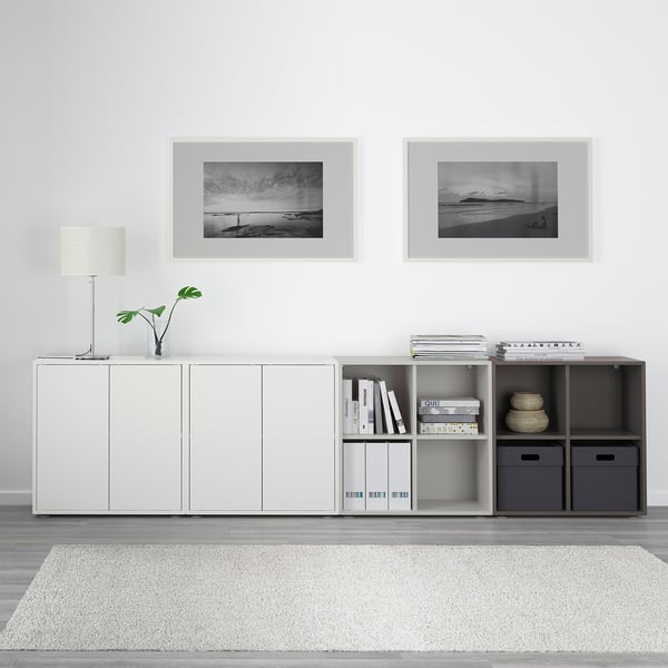 White EKET storage with mix of closed and open shelves, black & white photos, lamp, books, decor, soft rug.