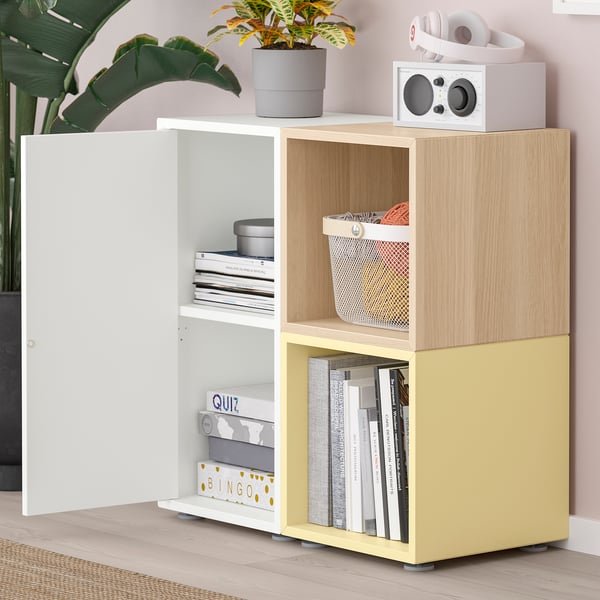 Modern storage unit with open and closed compartments, featuring books, a speaker, and headphones.