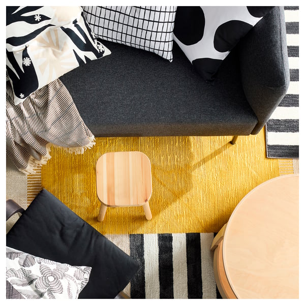 Bright yellow ELSYSTEM patchwork rug with playful shapes and black stripes. Soft, recycled polyester material.