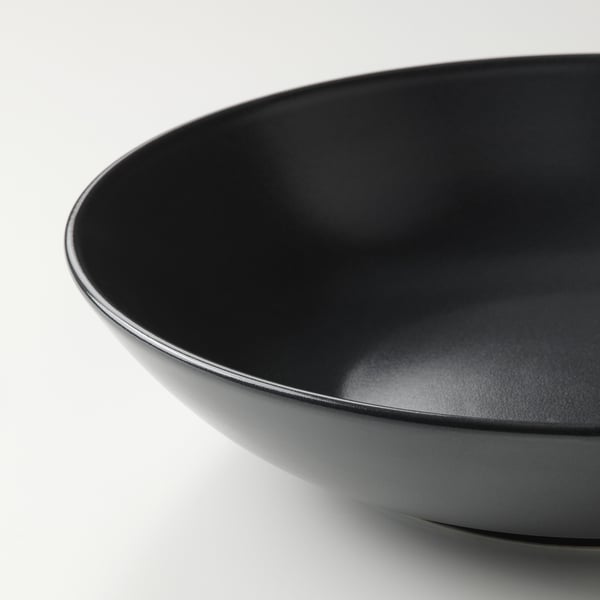 Black glazed stoneware bowl, smooth and sleek, shown in close-up highlighting its modern design and high-quality finish.