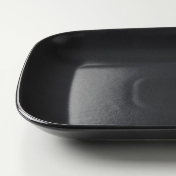 Smooth, glossy black stoneware plate, round edges, modern design.