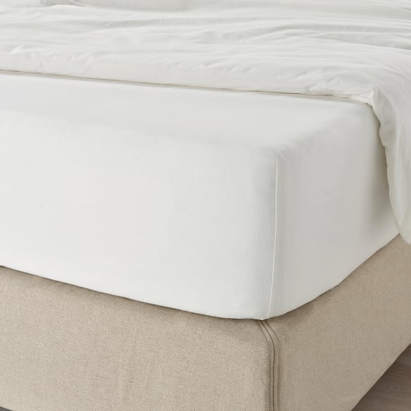 Crisp white bed with fitted sheet for 26cm mattresses.