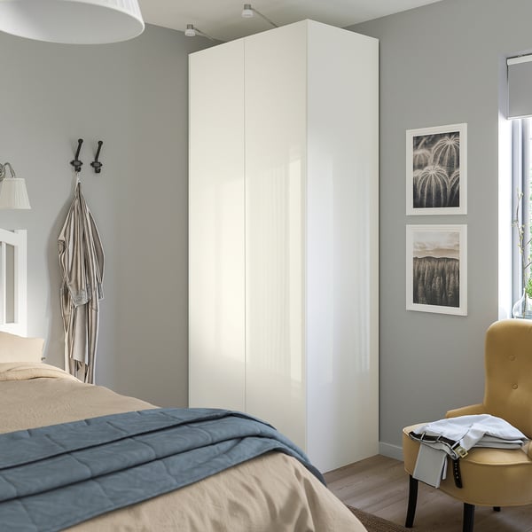 Bedroom featuring FARDAL glossy white wardrobe, tall and slim next to bed.