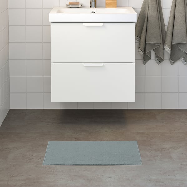 Small, light blue FINTSEN mat before white bathroom vanity.