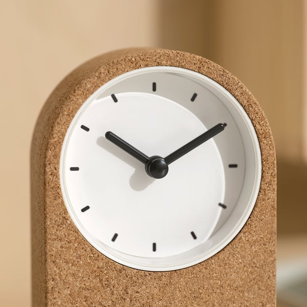 Minimalist clock with cork exterior, white face, black hands; silent operation.