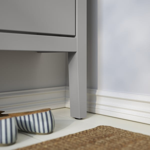 Grey GULLABERG shoe cabinet with stripe slippers.