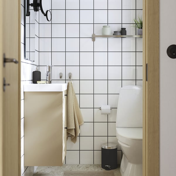 Modern bathroom with HAVBÄCK wall cabinet, white & beige, above toilet, black accents, simple decor.