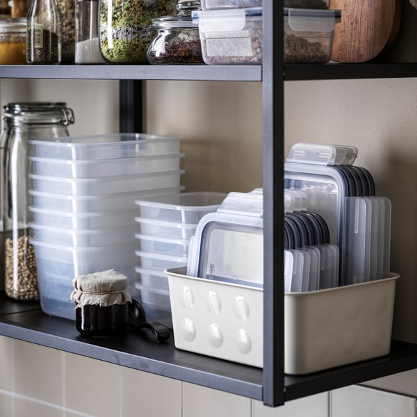 Shelf with clear food containers, lids, and jars. For storing leftovers and keeping food fresh.