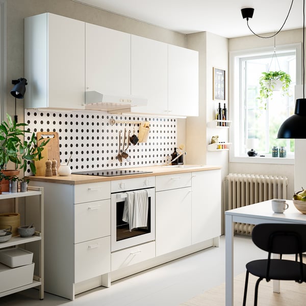 KNOXHULT white kitchen: modern design with storage, white cabinets, oak countertop, black polka-dot backsplash, clean layout.