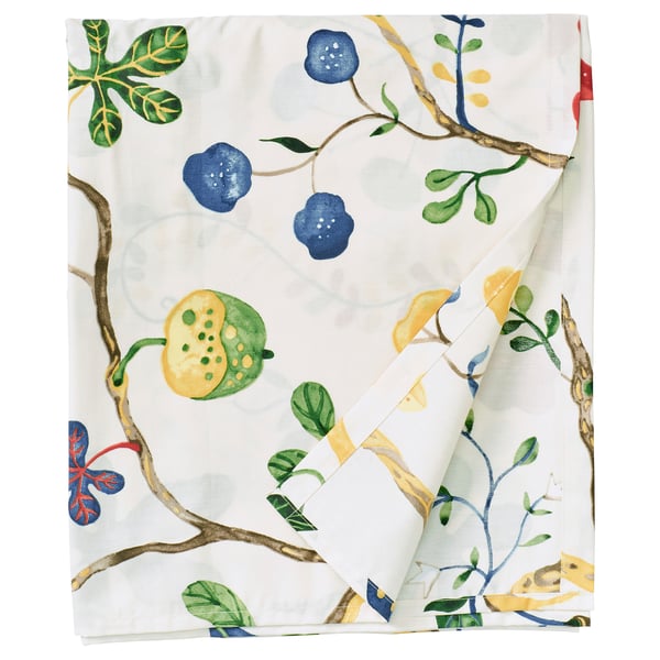 Folded KRONBUSKE cloth, white with green, yellow, and blue fruit prints, rectangular shape, intricate design.