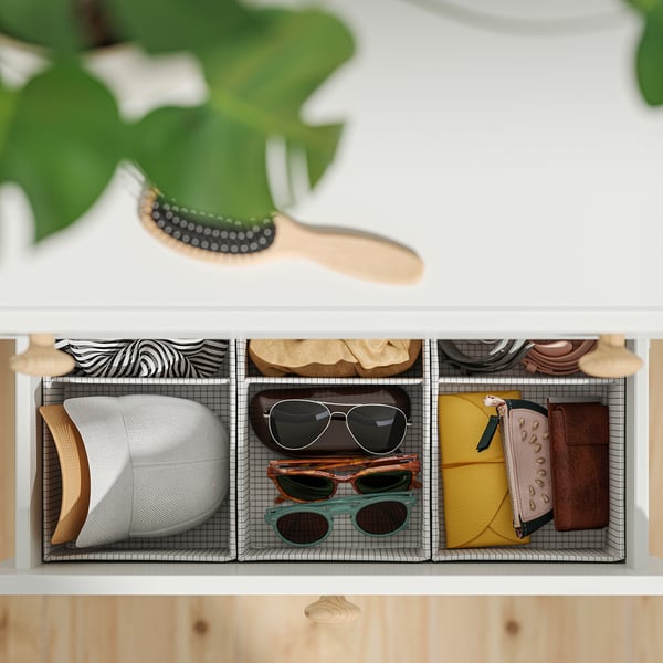 Organised drawer storage with compartments holding hats, sunglasses, and wallets.