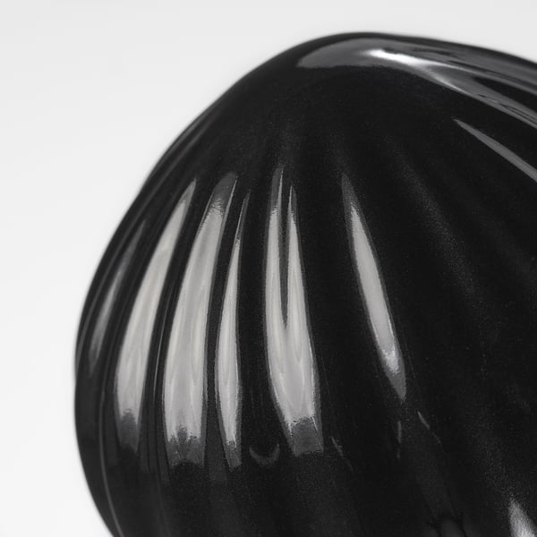 Close-up black glazed stoneware finial, sleek and reflective, showcasing elegant ribbed texture.