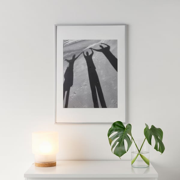 Black-and-white artwork of celebrating hands, with candle and plant for warmth.